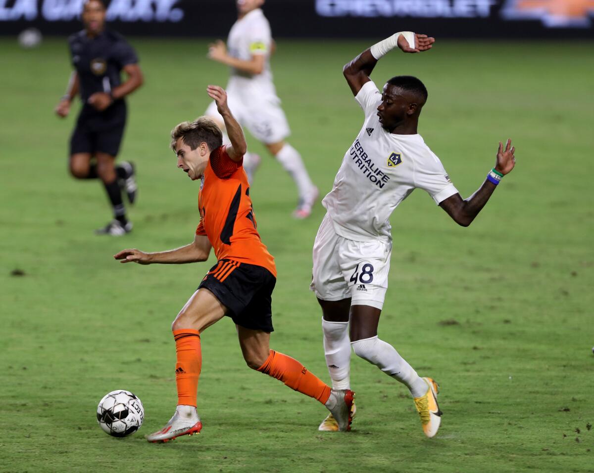 Orange County Soccer Club midfielder Brian Iloski is tripped up by Augustine Williams.