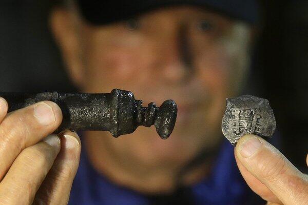 Explorer Barry Clifford holds a piece of eight, right, and a metal syringe salvaged from the wreck of the pirate ship Whydah. In 1984, Clifford discovered the site of the 1717 wreck and has retrieved more than 200,000 artifacts.