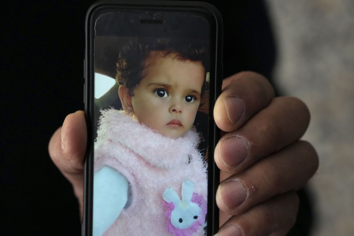 Jalal al-Masri holds a picture of his daughter, Fatma, a 19-month-old who was diagnosed with a congenital heart defect in December 2021, and died as the family waited another three months for an Israeli permit to take her for treatment outside the Gaza Strip, in Khan Younis, southern Gaza Strip, Tuesday, April 12, 2022. The death of Fatma has shone a light on the struggles faced by Palestinians from the isolated territory who require urgent medical care. Israel and Egypt have imposed a blockade on Gaza since the Islamic militant group Hamas seized power there nearly 15 years ago. (AP Photo/Adel Hana)