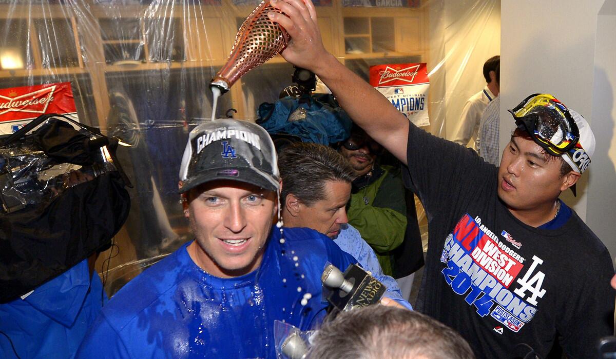Catcher A.J. Ellis is doused by pitcher Hyun-Jin Ryu in the clubhouse after the Dogers defeated the San Francisco Giants, 9-1, to clinch the NL West title on Sept. 24.
