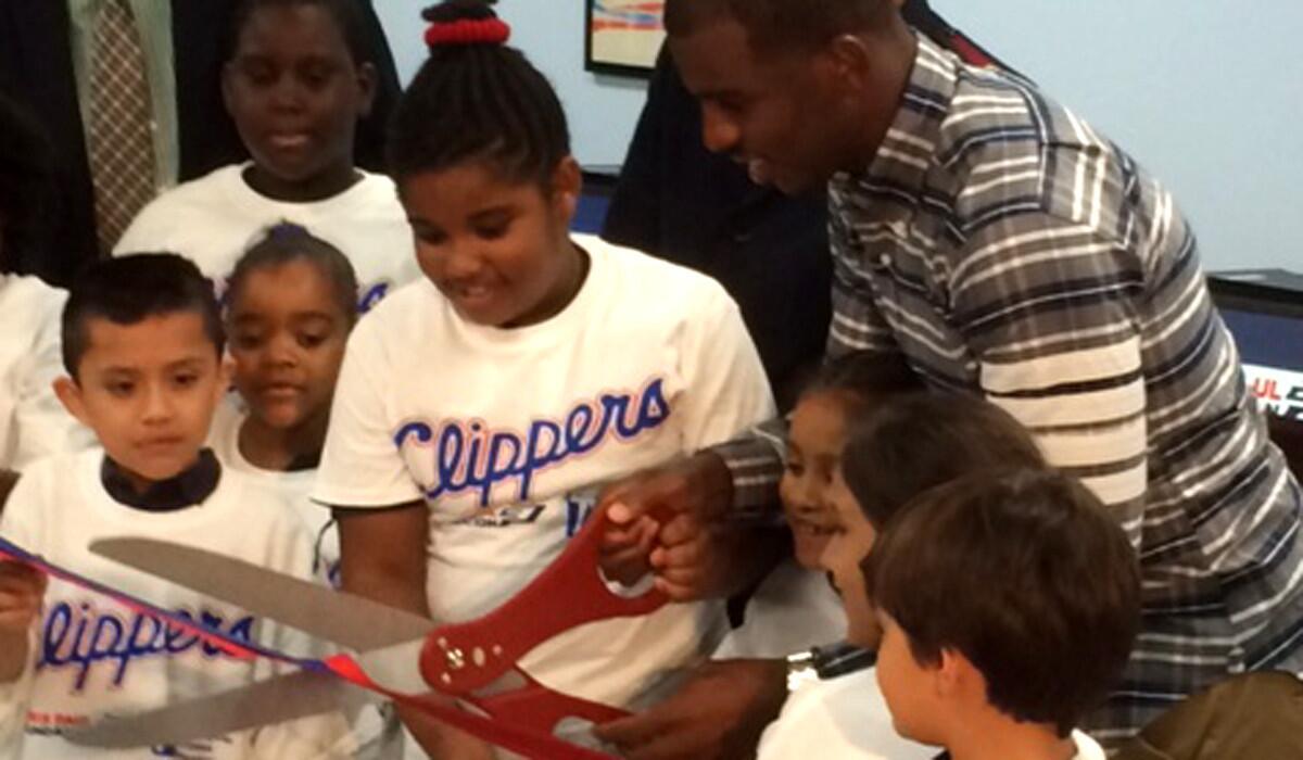 Clippers All-Star point guard Chris Paul helps with the ribbon-cutting at the renovated Salvation Army community center Monday.