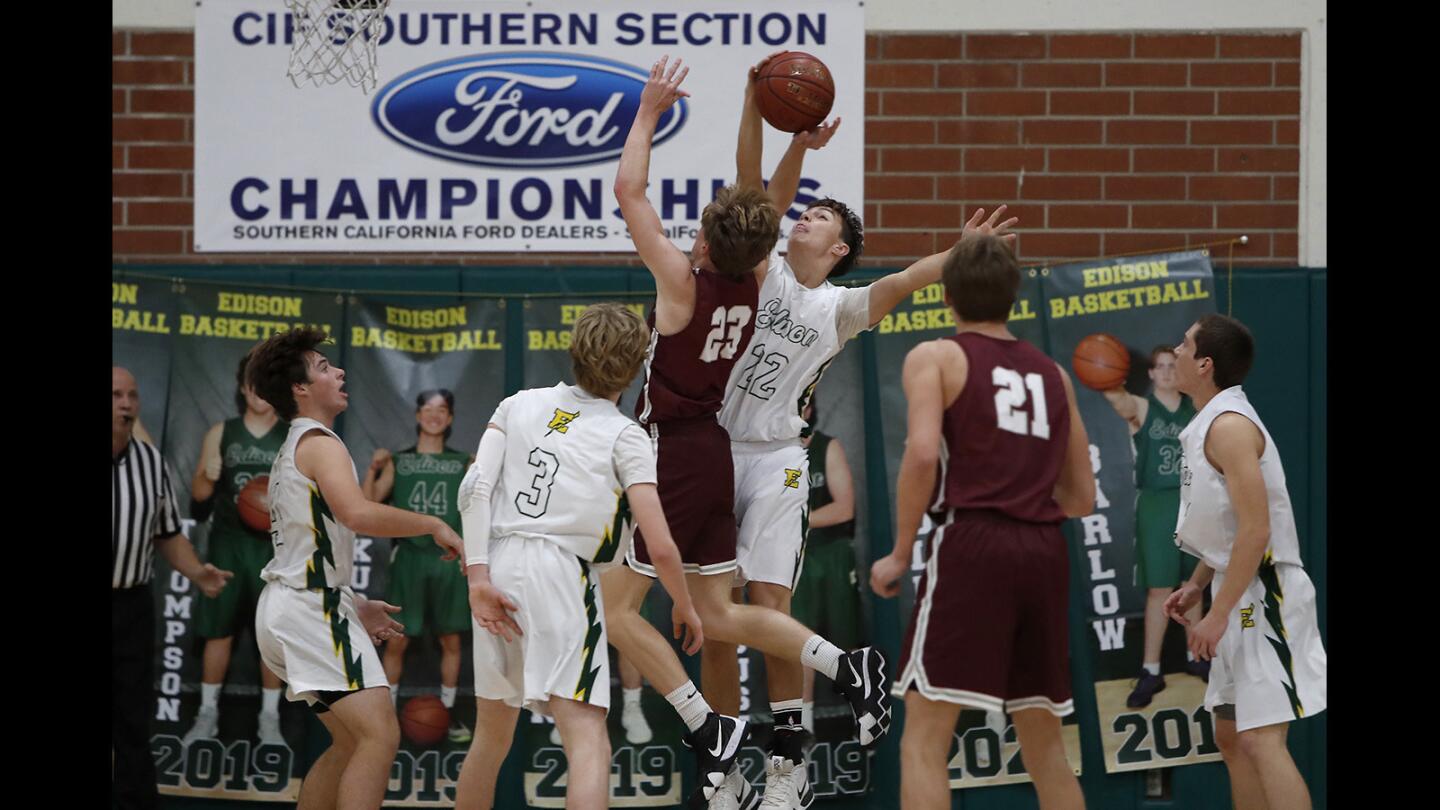 Edison High's Connor Collins (22) blocks Laguna Beach's Brooks Hogenauer (23) during the first half in a Sunset Conference crossover game at Edison High on Wednesday, December 19, 2018.