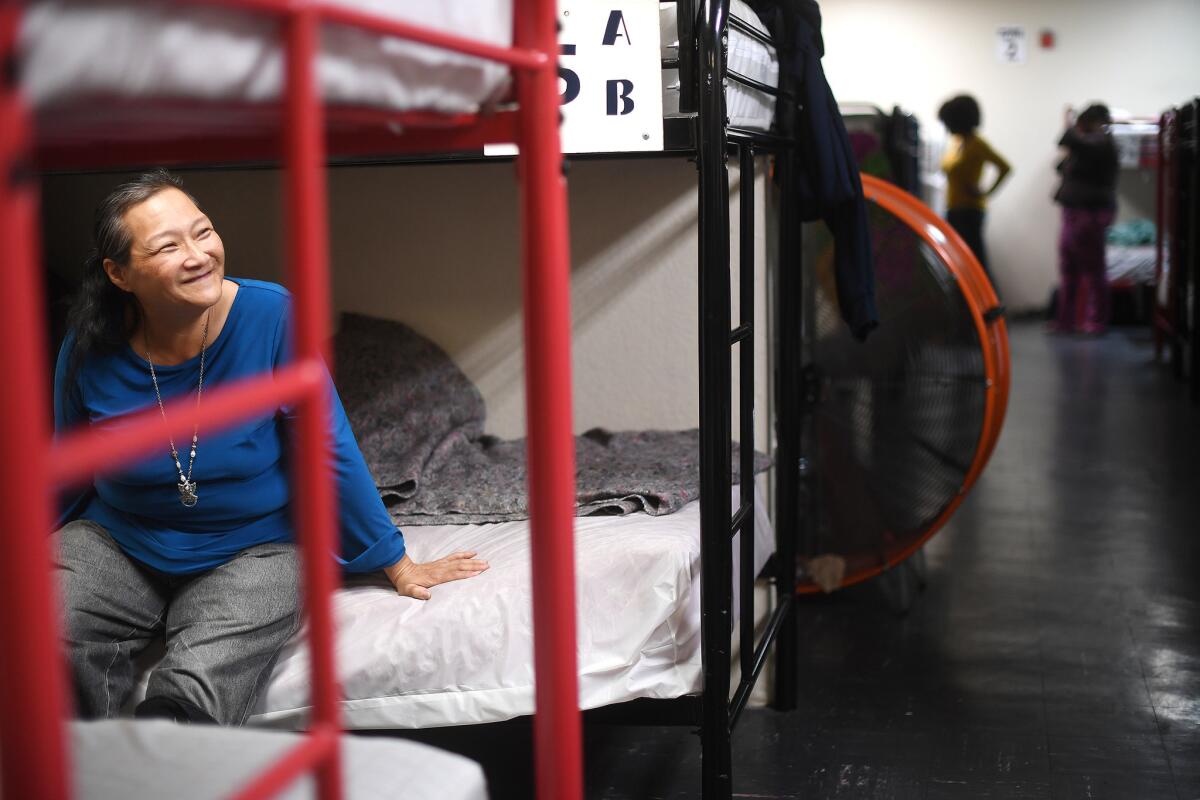 Barbara Siemens, 58, rests on her bunk bed at a women's shelter run by Volunteers of America in Los Angeles. The shelter is one of the biggest women's shelters in L.A.