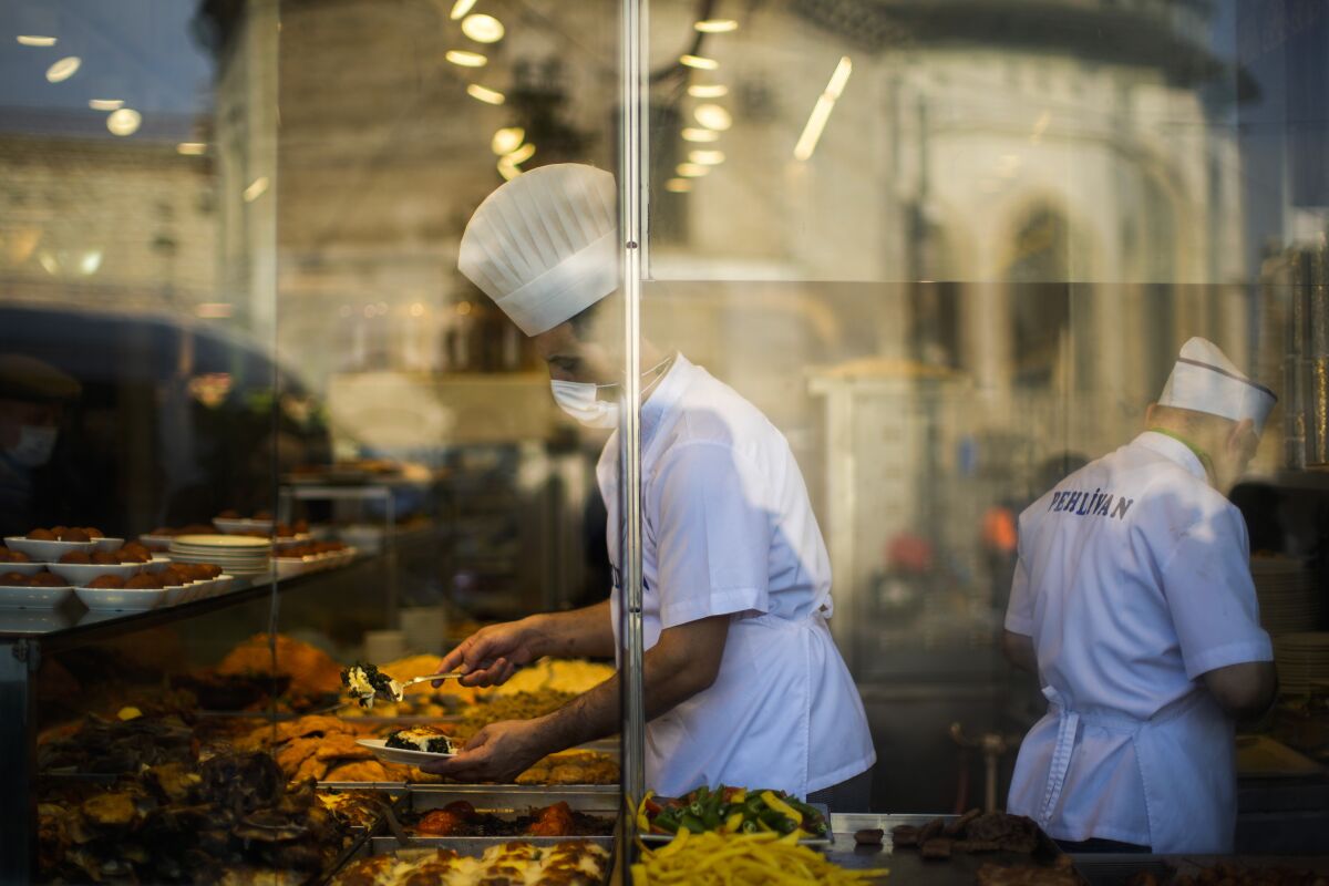A chef serves meals to clients in a local 'lokantasi' or popular restaurant in Istanbul, Turkey, Monday, Jan. 3, 2022. Turkey's yearly inflation climbed by the fastest pace in 19 years, jumping to 36.08% in December, official data showed on Monday. (AP Photo/Francisco Seco)
