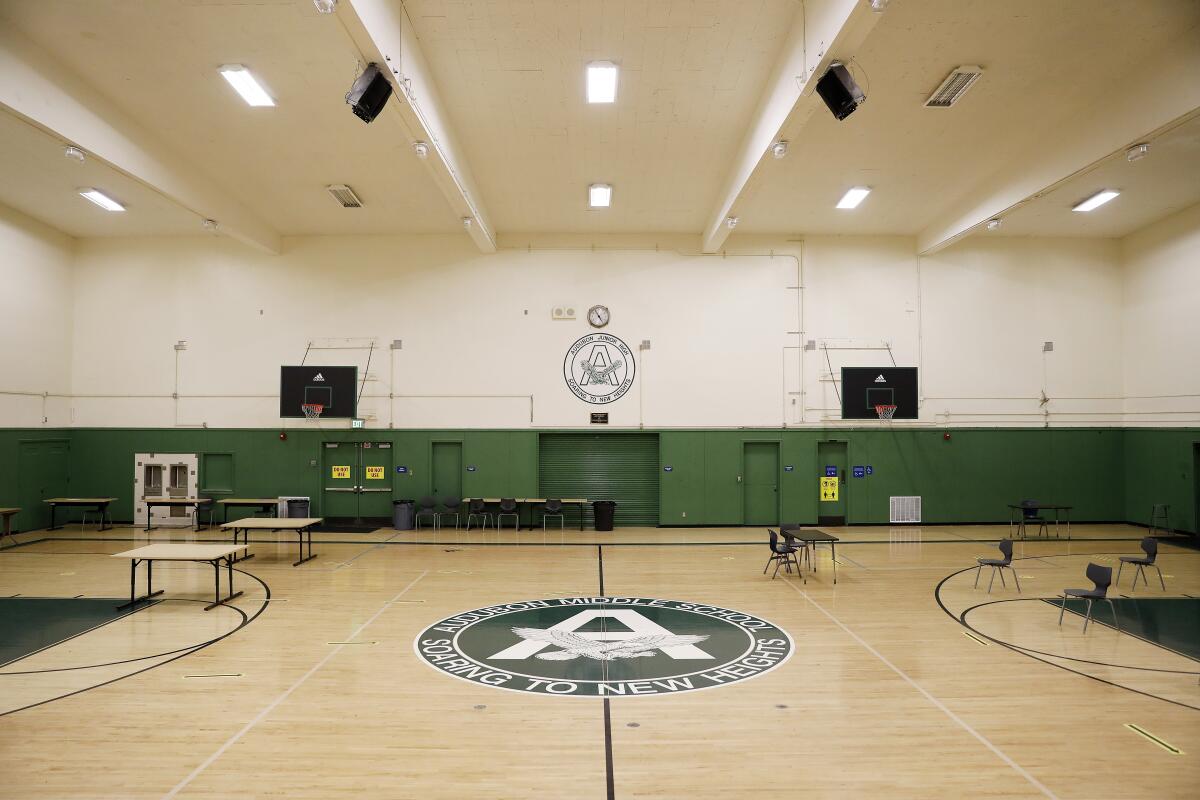 An empty gym with a school logo in the center of the floor: "Aububon Middle School: Soaring to New Heights."