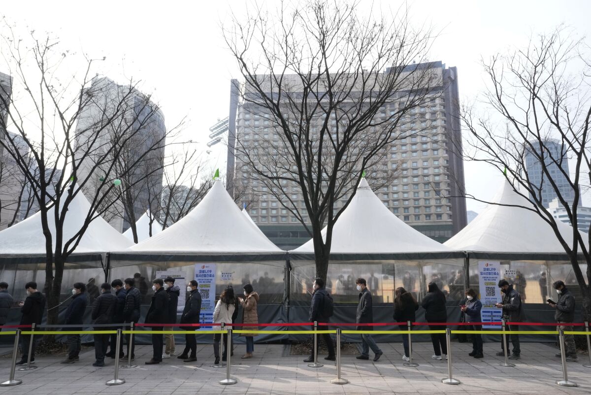 People wait for a coronavirus test at a makeshift testing site in Seoul, South Korea, Friday, March 4, 2022. (AP Photo/Ahn Young-joon)
