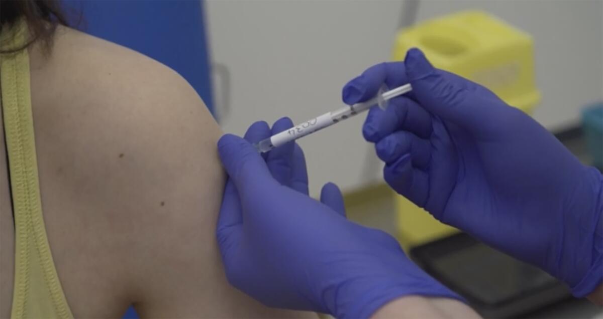 A person being injected as part of the first human trials in Britain to test a potential COVID-19 vaccine