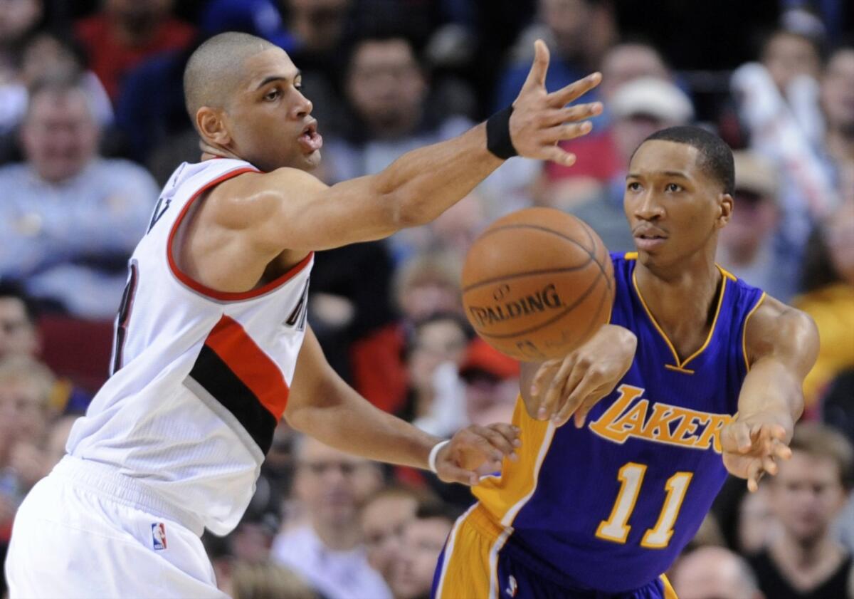 Wesley Johnson passes the ball as Trail Blazers forward Nicolas Batum defends during the second half of the Lakers' 102-86 loss to Portland.