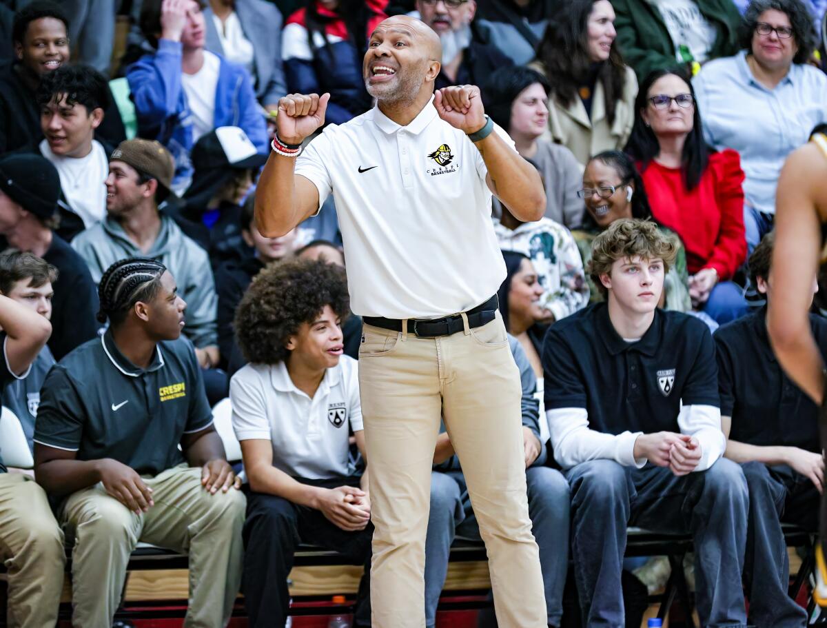Crespi basketball coach Derek Fisher on the sideline giving instruction to players on the court.