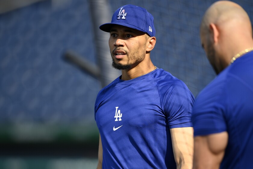 Dodgers center fielder Mookie Betts talks with Albert Pujols during batting practice.