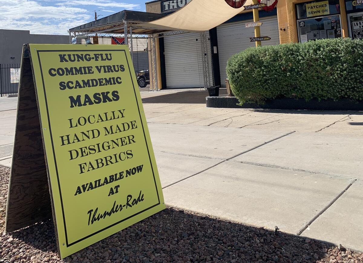 A sign outside Thunder-Rode motorcycle accessories store in Kingman, Ariz., touts "Kung-Flu Commie Virus Scamdemic Masks." 