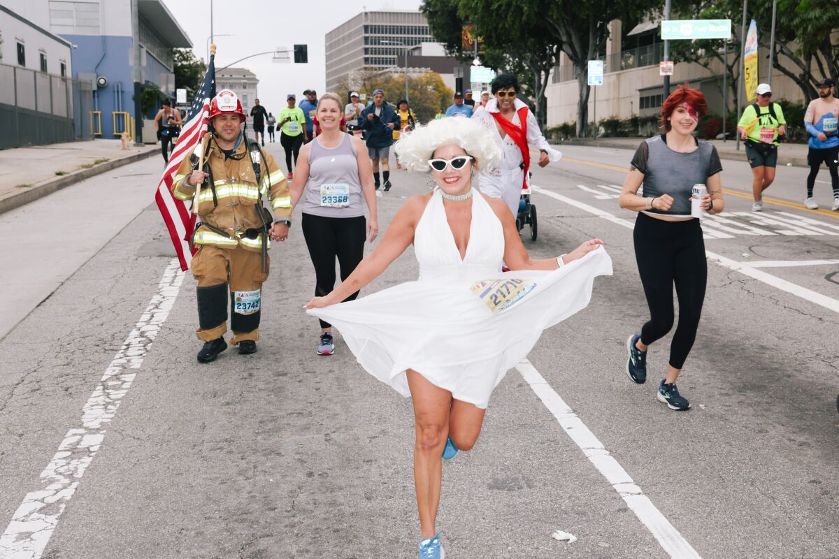 A runner dressed as Marilyn Monroe in a white dress, wig and sunglasses.