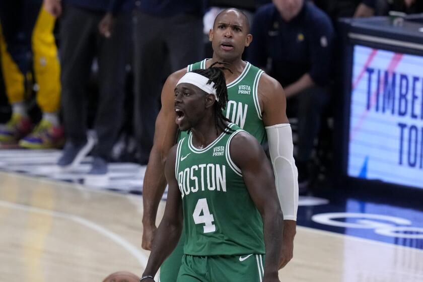 Boston Celtics guard Jrue Holiday (4) celebrates with teammate center Al Horford.