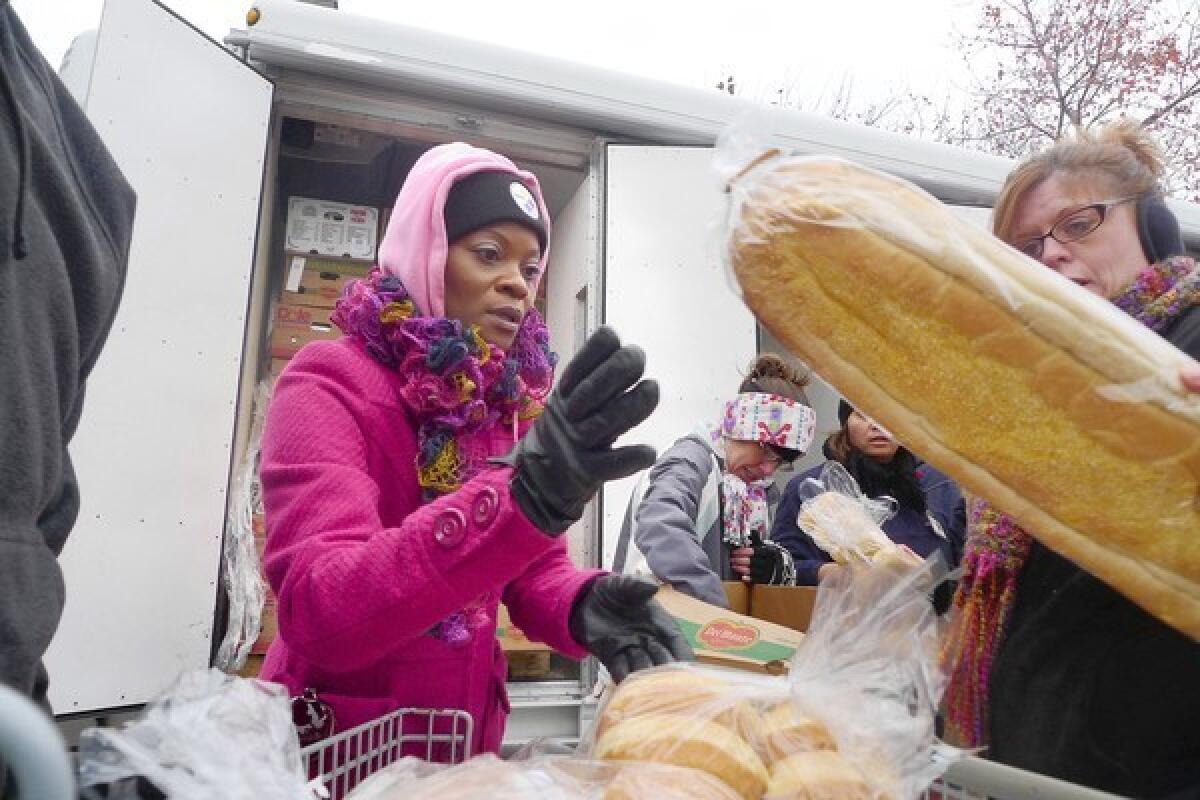 Healthcare navigator Quinetta Rascoe helps distribute food, along with business cards and information on the Affordable Care Act, to needy families in Murfreesboro, N.C.