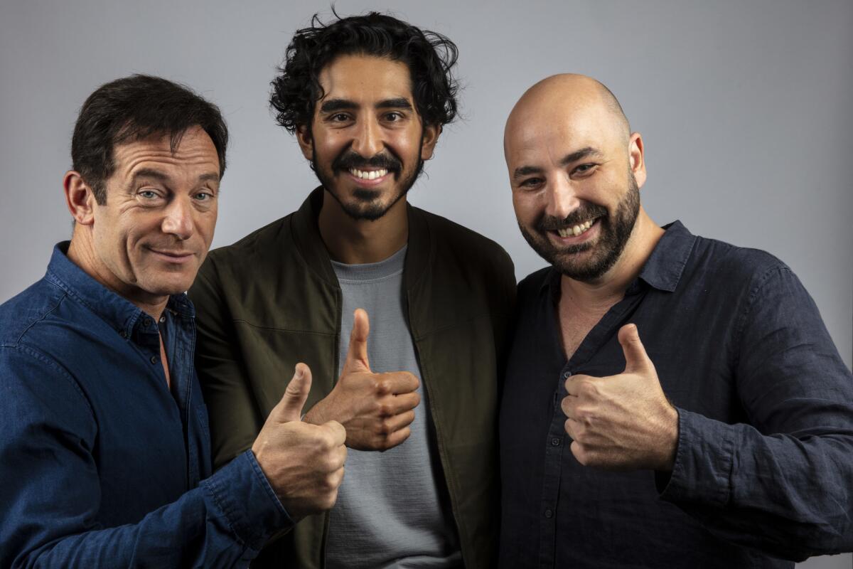 Actor Jason Isaacs, left, actor Dev Patel, and director Anthony Maras from the film "Hotel Mumbai."