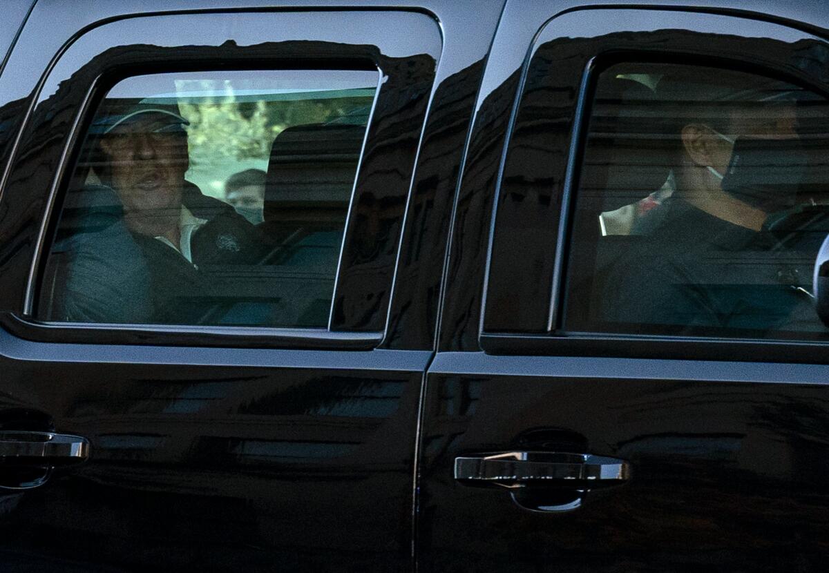 President Trump watches from his presidential state car after playing golf on Saturday.