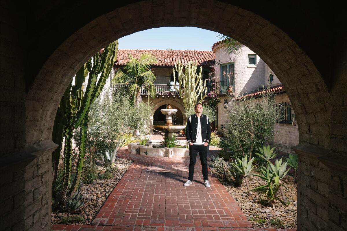 A man poses for a photo outside his home.