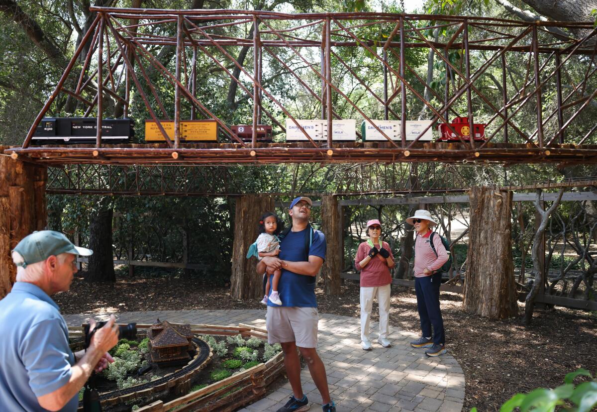 Guests looking up at a miniature train and elevated railway at Descanso Gardens model train experience.