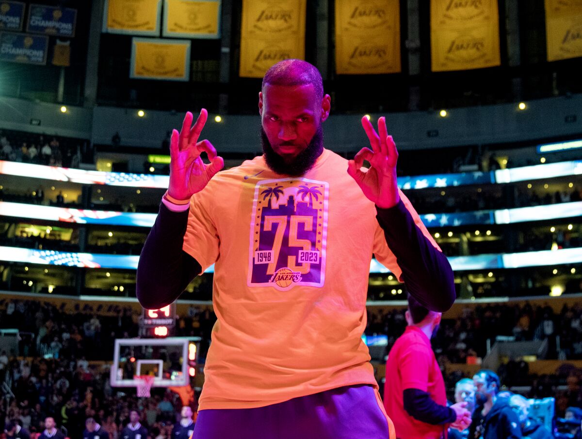 Lakers forward LeBron James gestures the "OK" sign with his hands before a game.