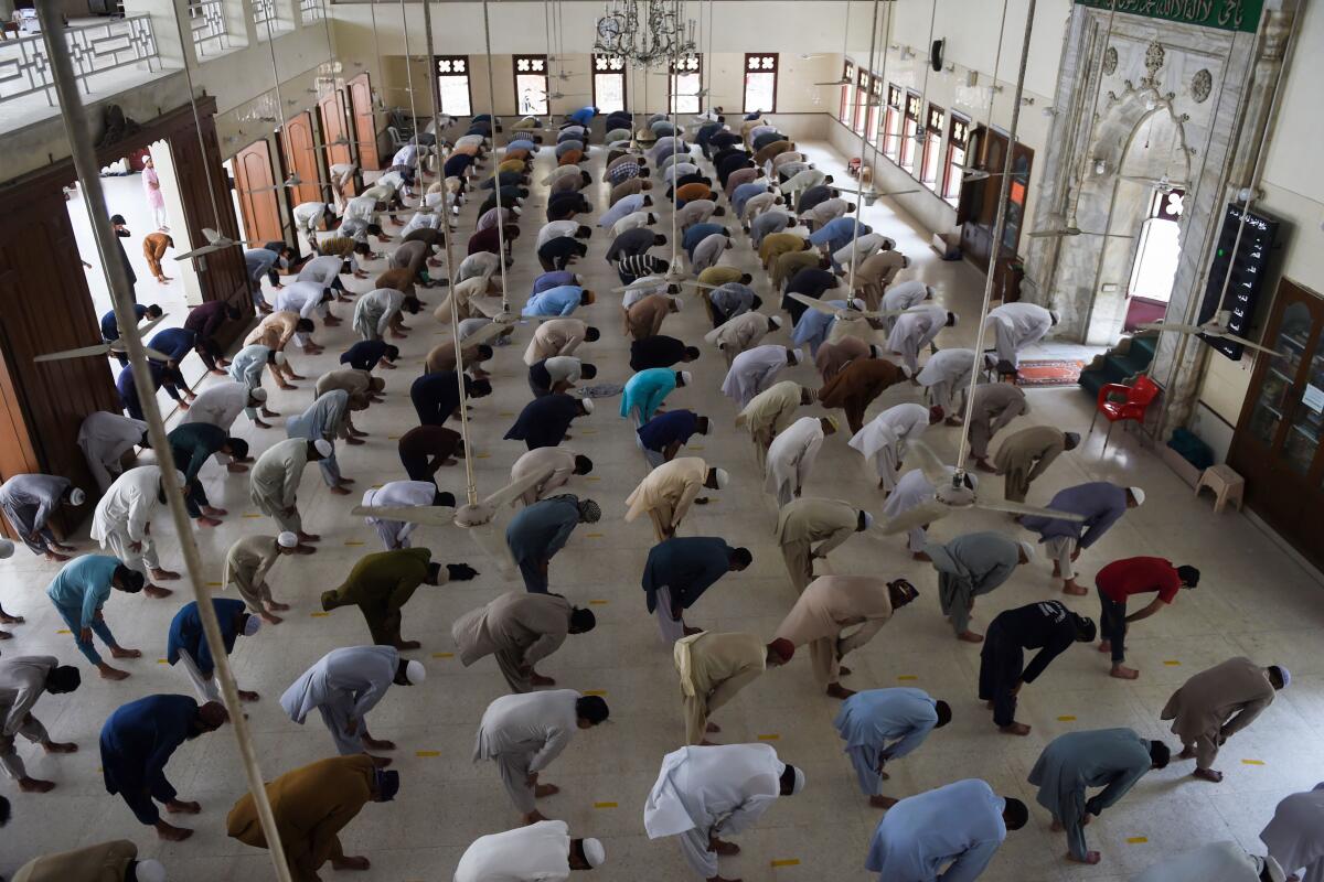 
Muslims practice social distancing during prayers last week at a mosque in Karachi, Pakistan.
