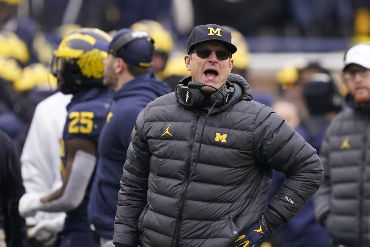 FILE -Michigan head coach Jim Harbaugh yells from the sideline during the second half of an NCAA college football game against Ohio State, Saturday, Nov. 27, 2021, in Ann Arbor, Mich. Michigan coach Jim Harbaugh has agreed to a reworked five-year contract with the school that runs through the 2026 season, Wednesday, Feb. 16, 2022. (AP Photo/Carlos Osorio, File)