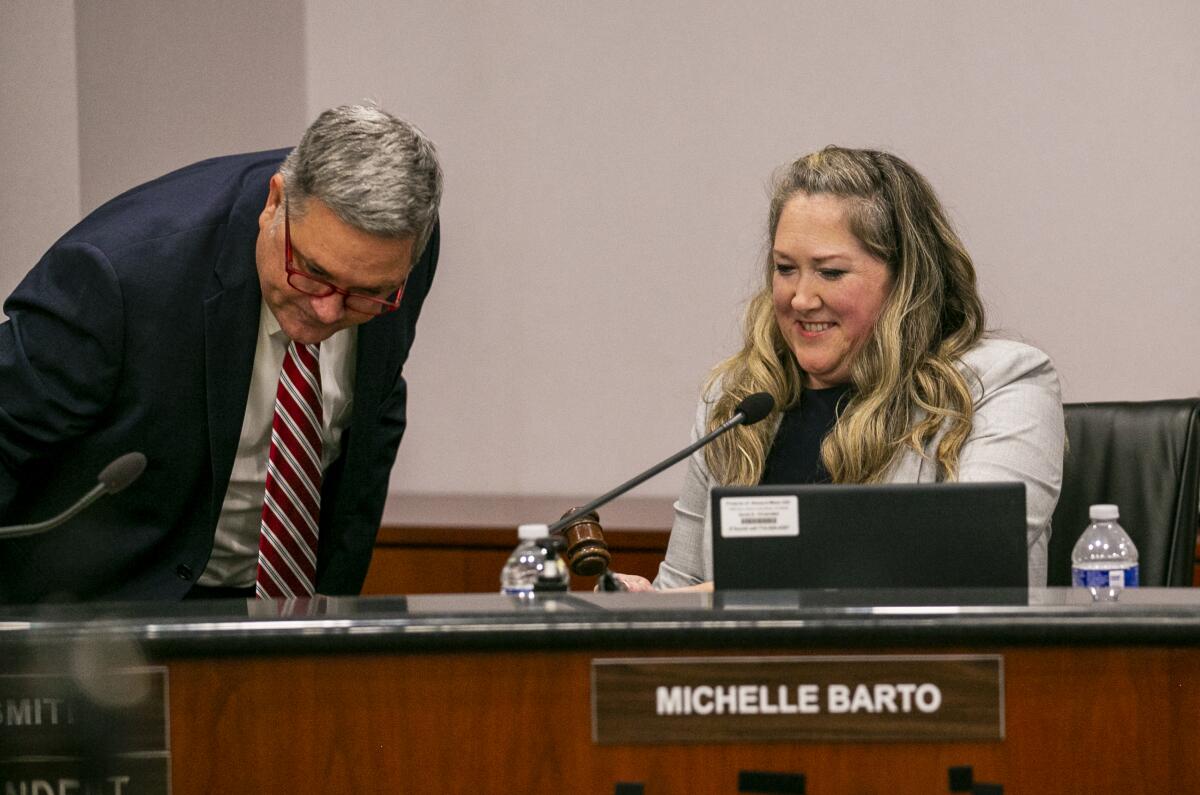 Newport-Mesa Unified Supt. Wes Smith hands incoming Board President Ashley Anderson a ceremonial gavel in a meeting Tuesday.