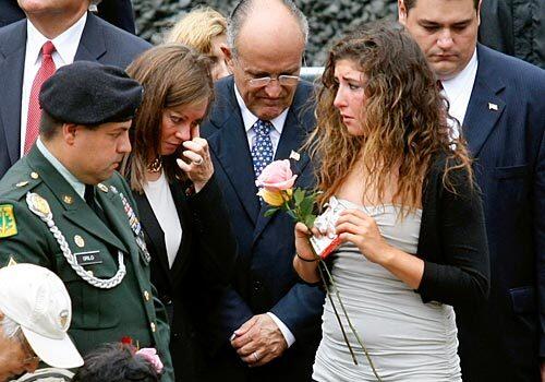 Republican presidential hopeful and former New York Mayor Rudolph Giuliani, center, stands with wife Judith, second from left, and victims' relatives at the World Trade Center site reflecting pool.