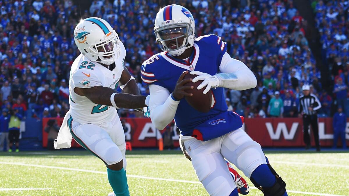Bills quarterback Tyrod Taylor scrambles past Dolphins cornerback Jamat Taylor during their game Sunday.