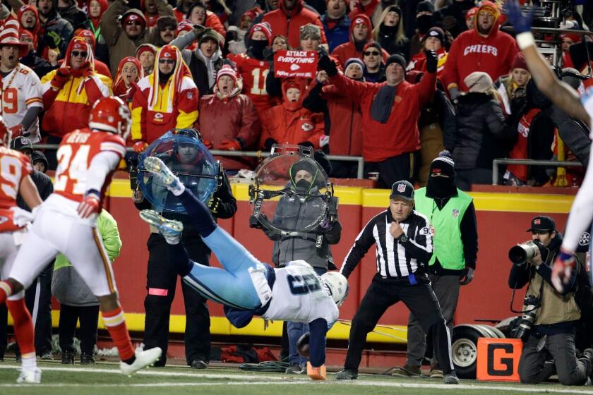 Tennessee Titans quarterback Marcus Mariota (8) leaps for a touchdown in front of Kansas City Chiefs defensive back Will Redmond (24) during the second half of an NFL wild-card playoff football game, in Kansas City, Mo., Saturday, Jan. 6, 2018. (AP Photo/Charlie Riedel)