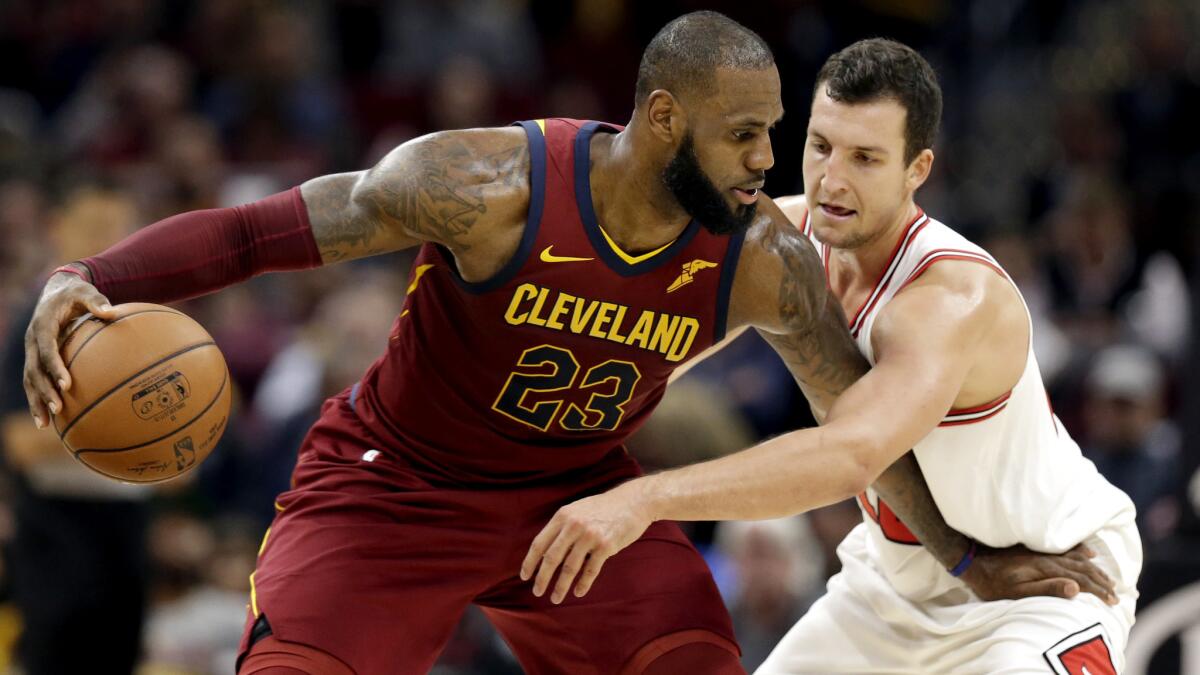 Cavaliers forward-turned-point guard LeBron James protects the ball from Bulls forward Paul Zipser while setting up the offense during their game Tuesday night.