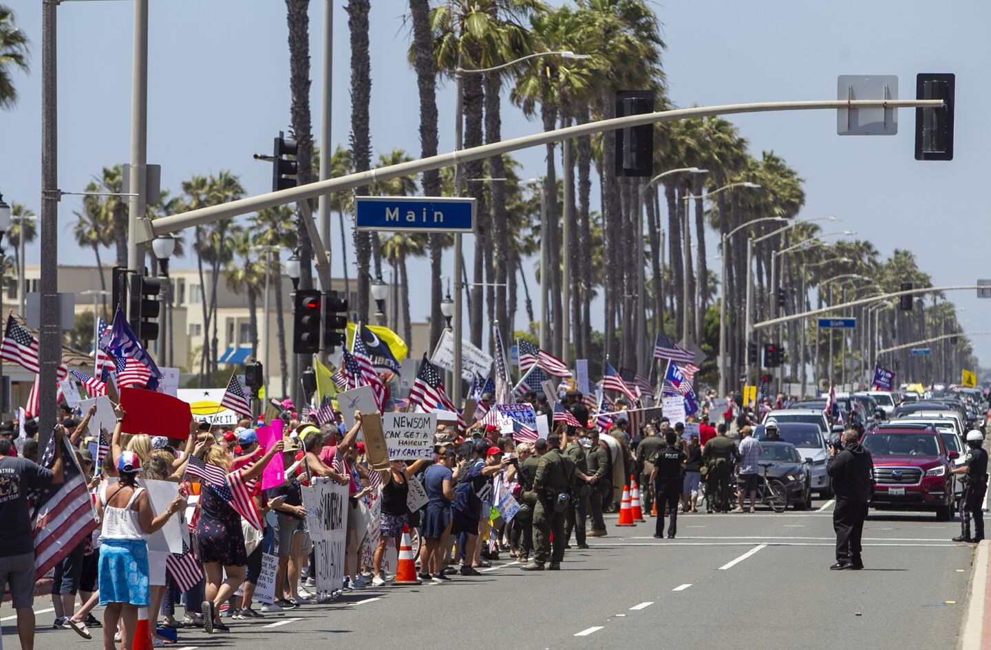 A large group of people line Pacific Coast Highway during a protest in Huntington Beach on Friday.