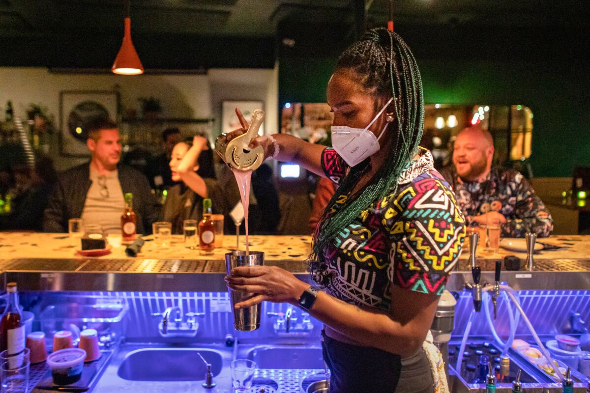 Tiffany Laster pours a cocktail behind the bar at Thunderbolt.