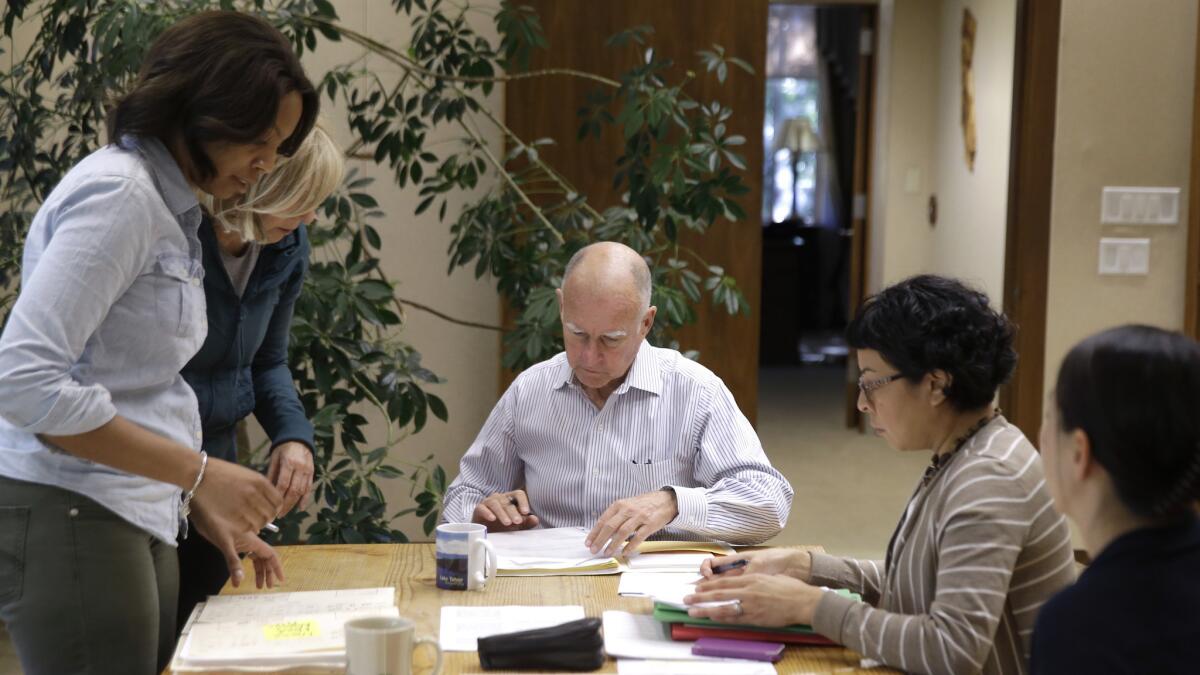 California Gov. Jerry Brown prepares to sign one of hundreds of bills he has left to take action on in his Capitol office in Sacramento on Oct. 9 of last year.