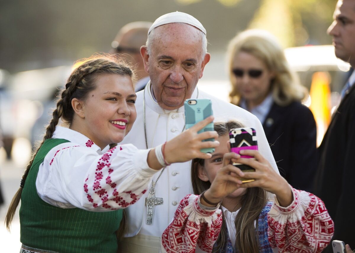 Pope Francis takes a photo with children whose parents work at the Lithuanian Embassy, outside the Apostolic Nunciature to the United States, in Washington.