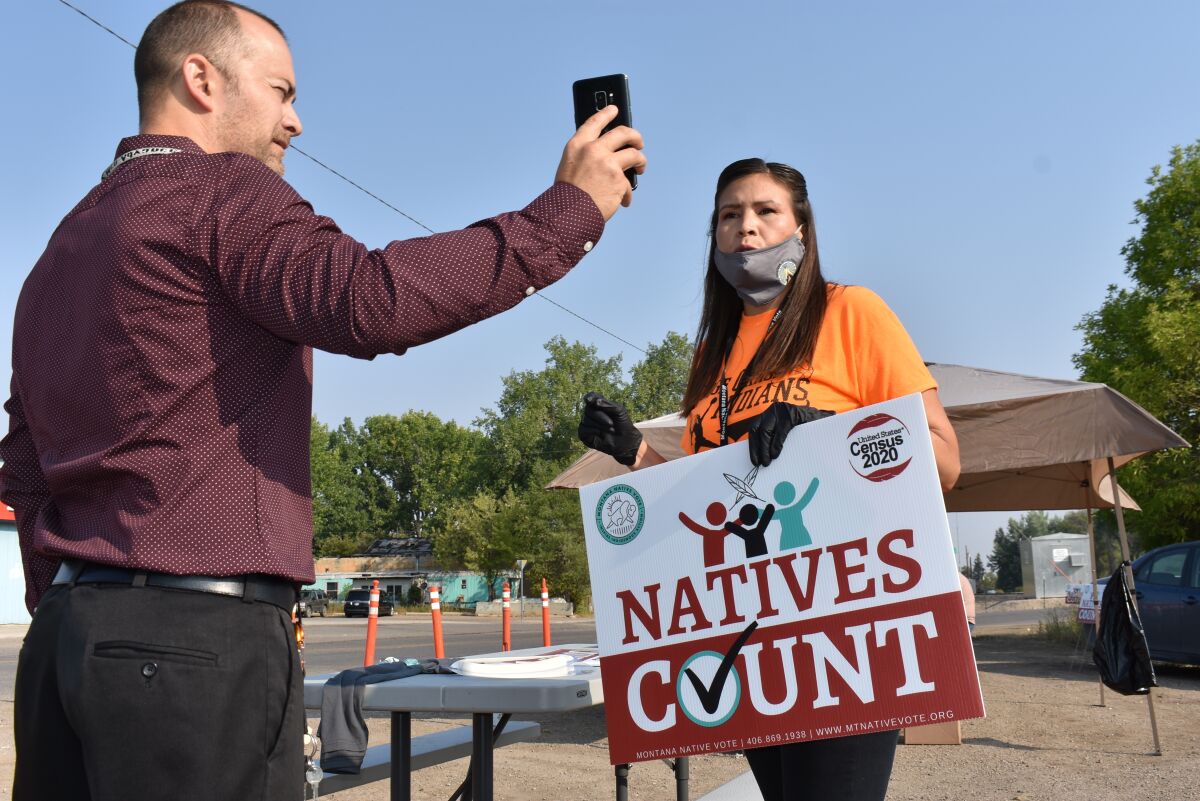 Activist Lauri Dawn Kindness, right, speaks at the Crow Indian Reservation, in Lodge Grass, Mont. on Wednesday, Aug. 26, 2020, as Lodge Grass Mayor Quincy Dabney records her for a social media campaign to increase Native American participation in the U.S. census. Kindness and other activists with Western Native Voice are trying to prevent an undercount of the tribe that could result in less federal funding. (AP Photo/Matthew Brown)