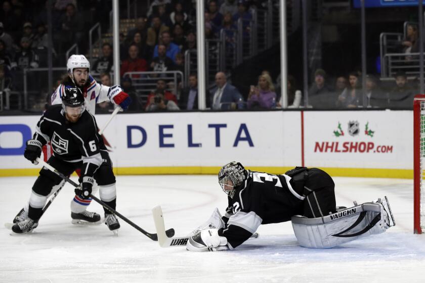 Los Angeles Kings goaltender Jonathan Quick, right, stops a shot against the New York Rangers during the first period of an NHL hockey game Tuesday, Dec. 10, 2019, in Los Angeles. (AP Photo/Marcio Jose Sanchez)