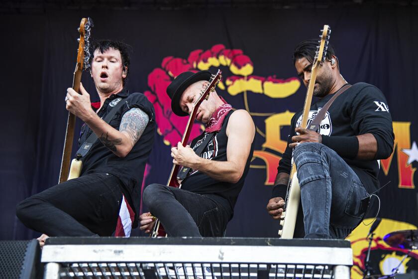 Musicians Jason McCaslin, from left, Tom Thacker and Dave Baksh of Sum 41 perform onstage