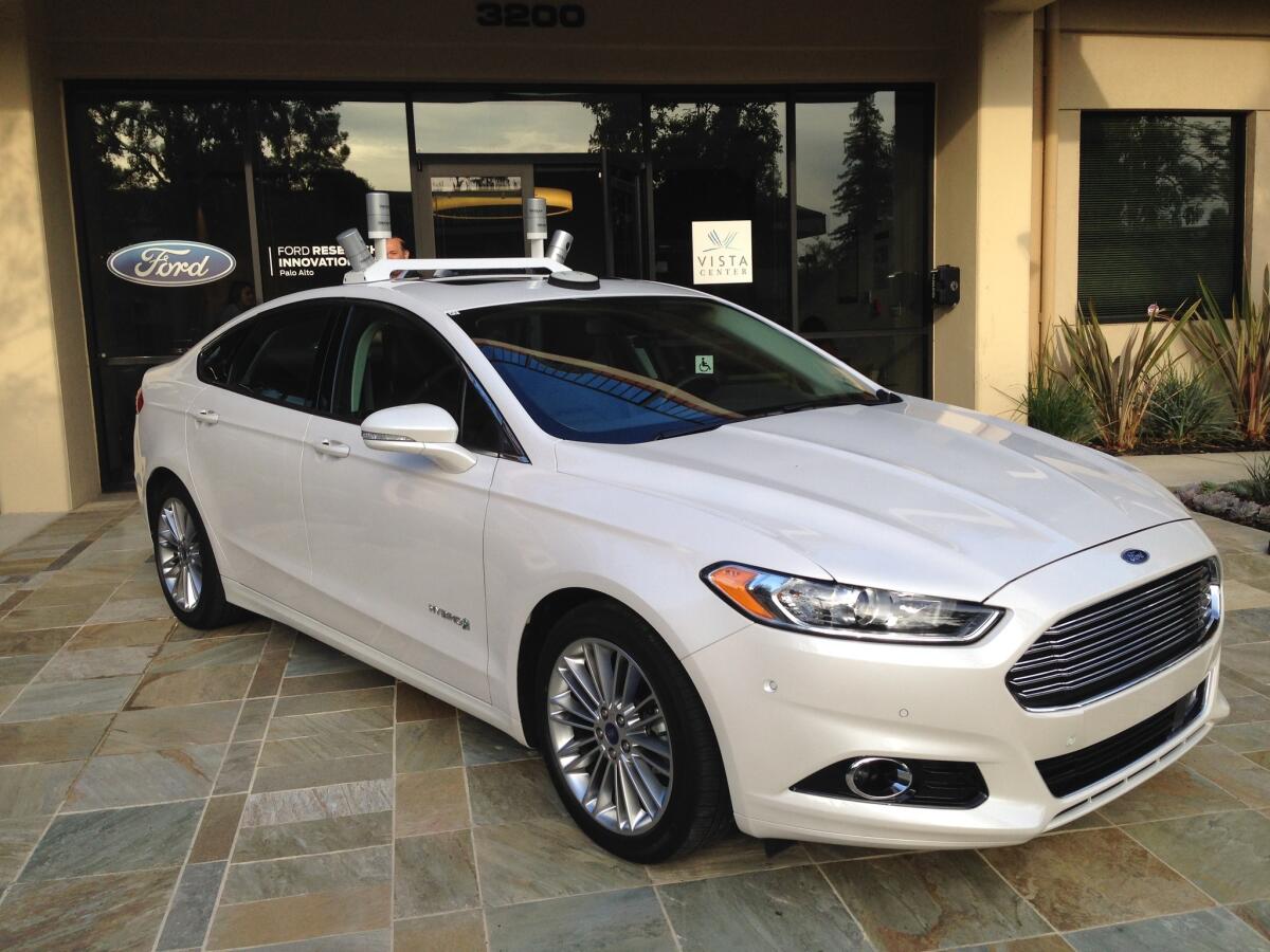 A Ford Fusion hybrid autonomous vehicle sits in front of the automaker's Research and Innovation Center that opened in Palo Alto on Thursday.