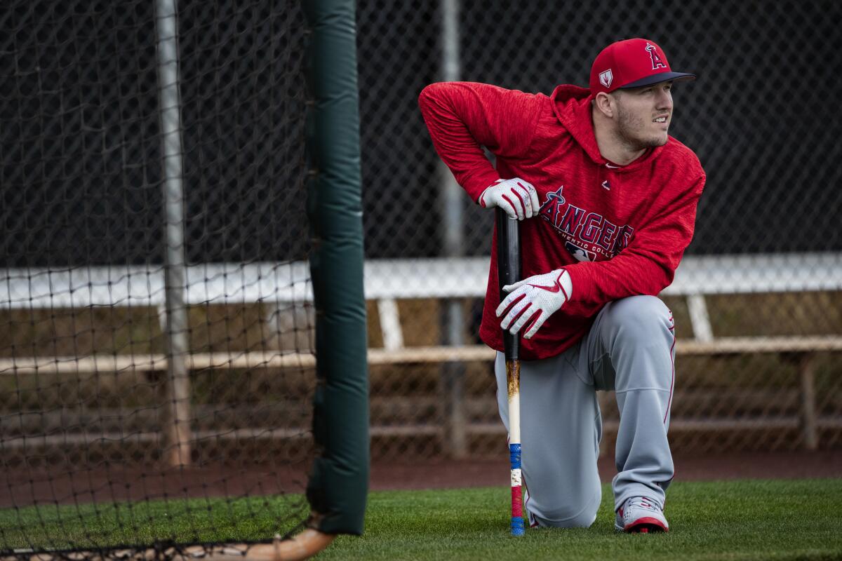 Angels center fielder Mike Trout takes a knee during a spring training practice session in Tempe, Ariz., on Monday.