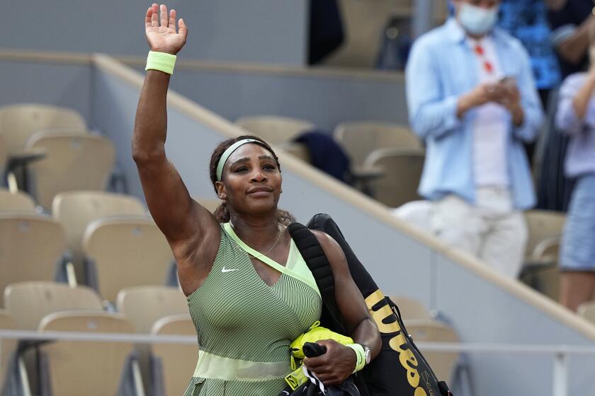 Serena Williams waves to the small crowd as she leaves court following her defeat by Kazakhstan's Elena Rybakina.