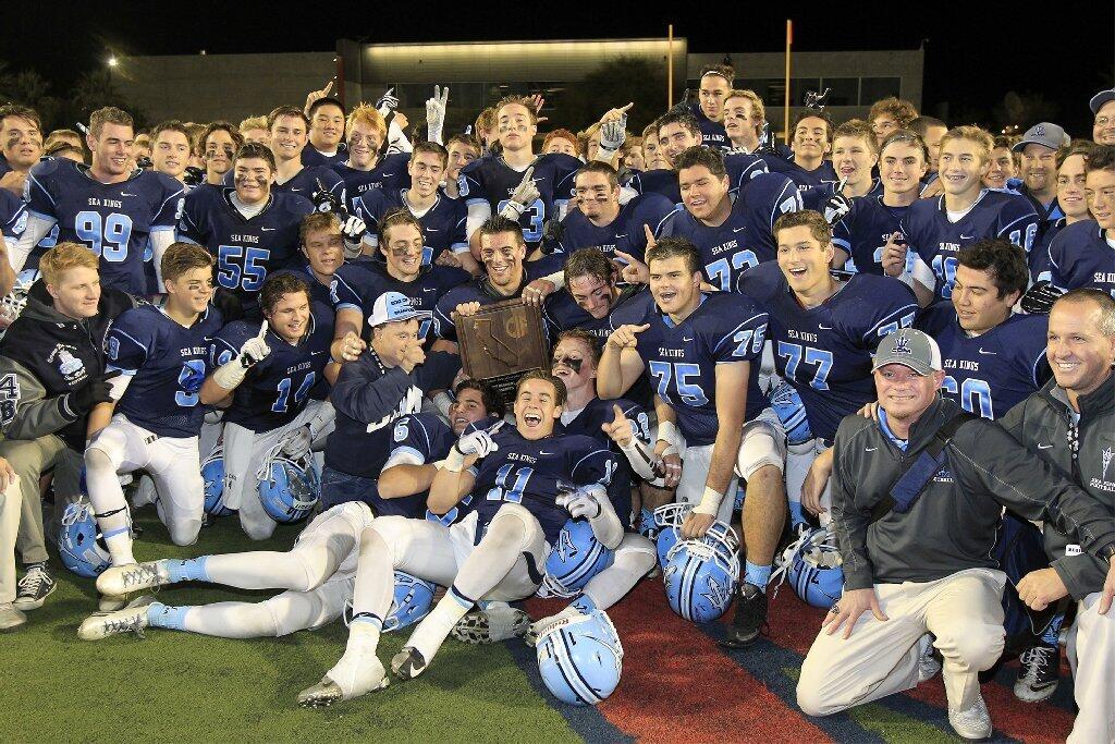The Corona del Mar High football team pose for a group photo with the Southern California Regional Division III championship plaque after beating Nordhoff, 24-8, in the CIF State Southern California Regional Division III Bowl Game at LeBard Stadium in Costa Mesa on Saturday.