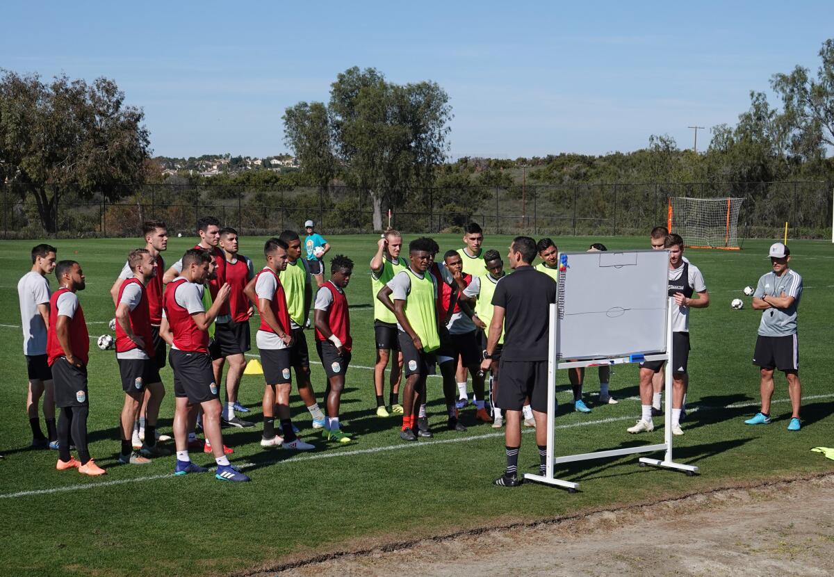 San Diego Loyal soccer team assistant coach Nate Miller talks to the team during a practice at the Chula Vista Elite Athlete Training Center on Jan. 28.  Coach Landon Donovan, right, looks on.