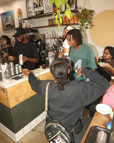 A barista makes a drink for waiting customers at Patria Coffee Roasters