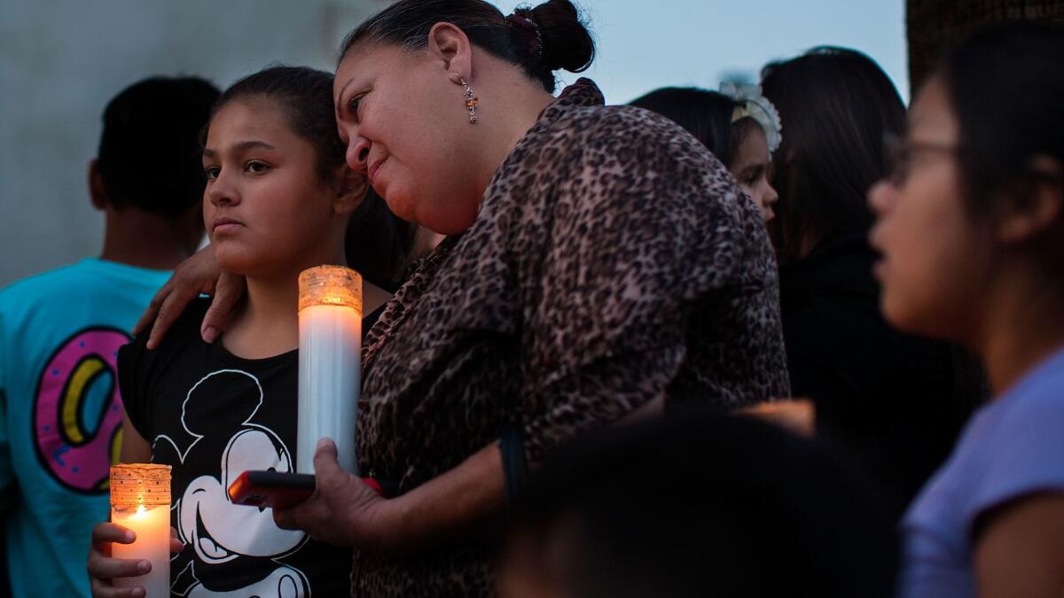 Betty Rodriguez hugs her granddaughter Giselle Rodriguez, 11, during a prayer vigil outside Our Lady of Assumption Catholic Church for the victims in the shooting at North Park Elementary School.