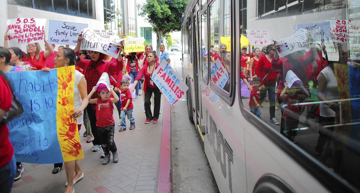 Families and teachers hold signs in protest of LAUSD's proposed closure of a family literacy program in May. The district revealed a plan to allow the program to continue, but in a scaled-down format.