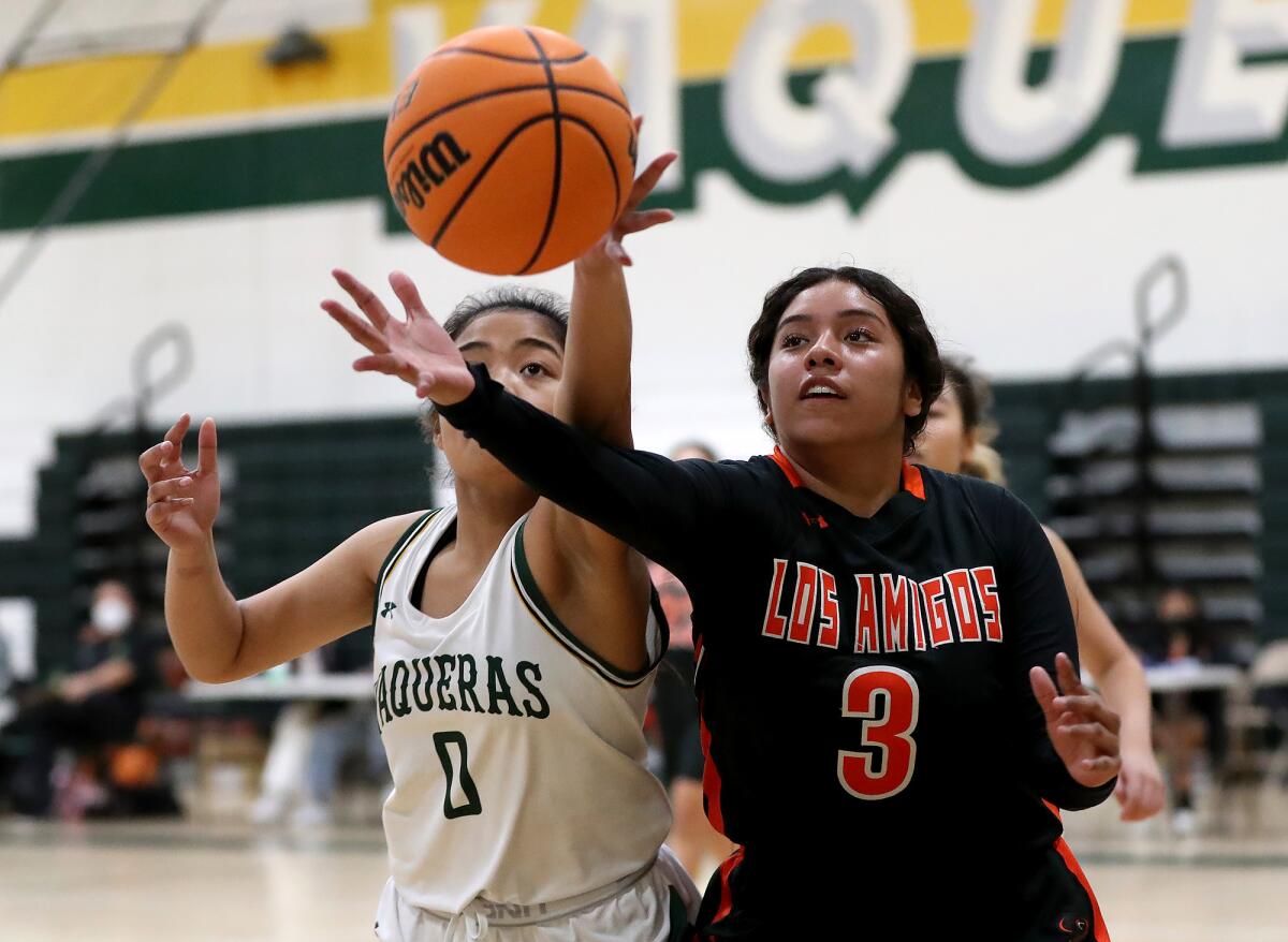 Los Amigos' Amber Rangel (3) and Rancho Alamitos' Jaelin Tabaniag (0) chase a loose ball.