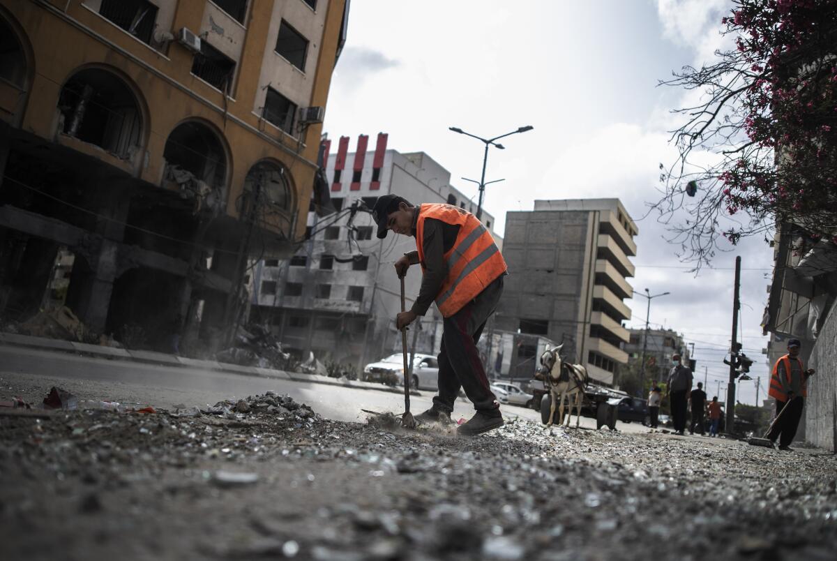 Palestinian municipal workers clean the streets of Gaza City following a cease-fire reached with Israel on May 21. 
