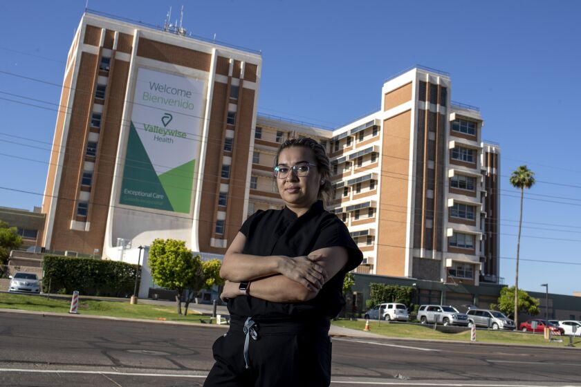 PHOENIX, AZ - MAY 21: Valleywise Health Medical Center nurse Karen Garcia sits for a portrait outside the hospital on Thursday, May 21, 2020 in Phoenix, AZ. Garcia is among 27,000 immigrants with DACA protections working on the frontlines combating COVID-19. But her future remains in limbo as the Supreme Court is set to decide in the weeks ahead whether immigrants like her will be allowed to remain in the country. (Brian van der Brug / Los Angeles Times)