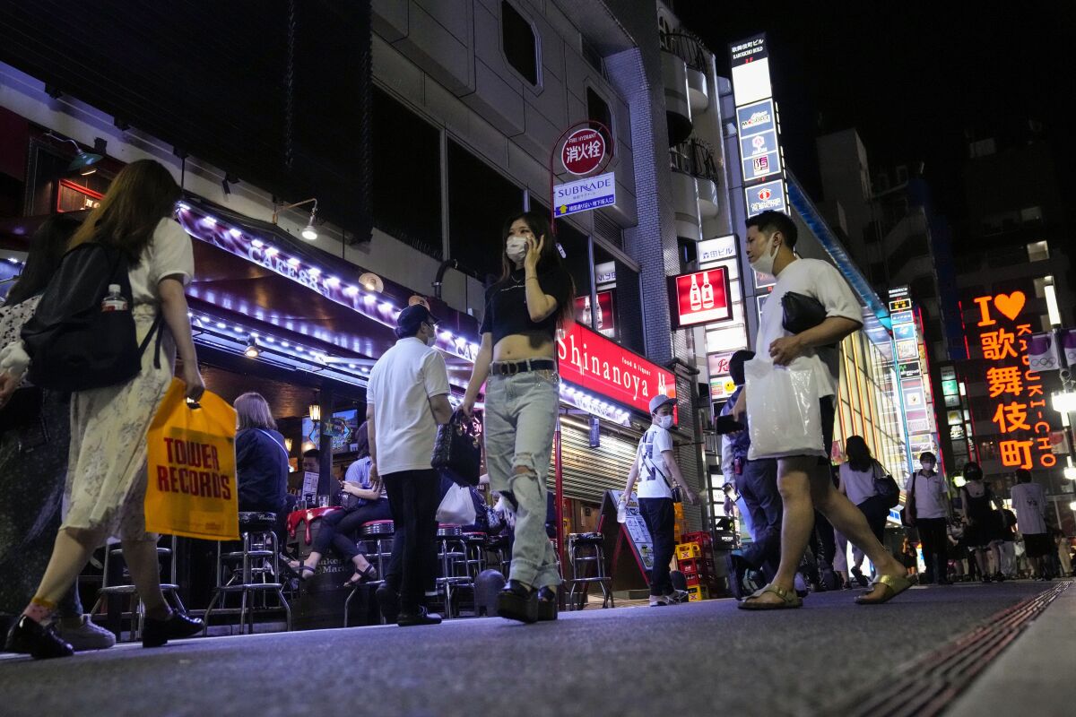 People walk around after the 8 p.m. closing time for restaurants and bars under Tokyo's fourth state of emergency.