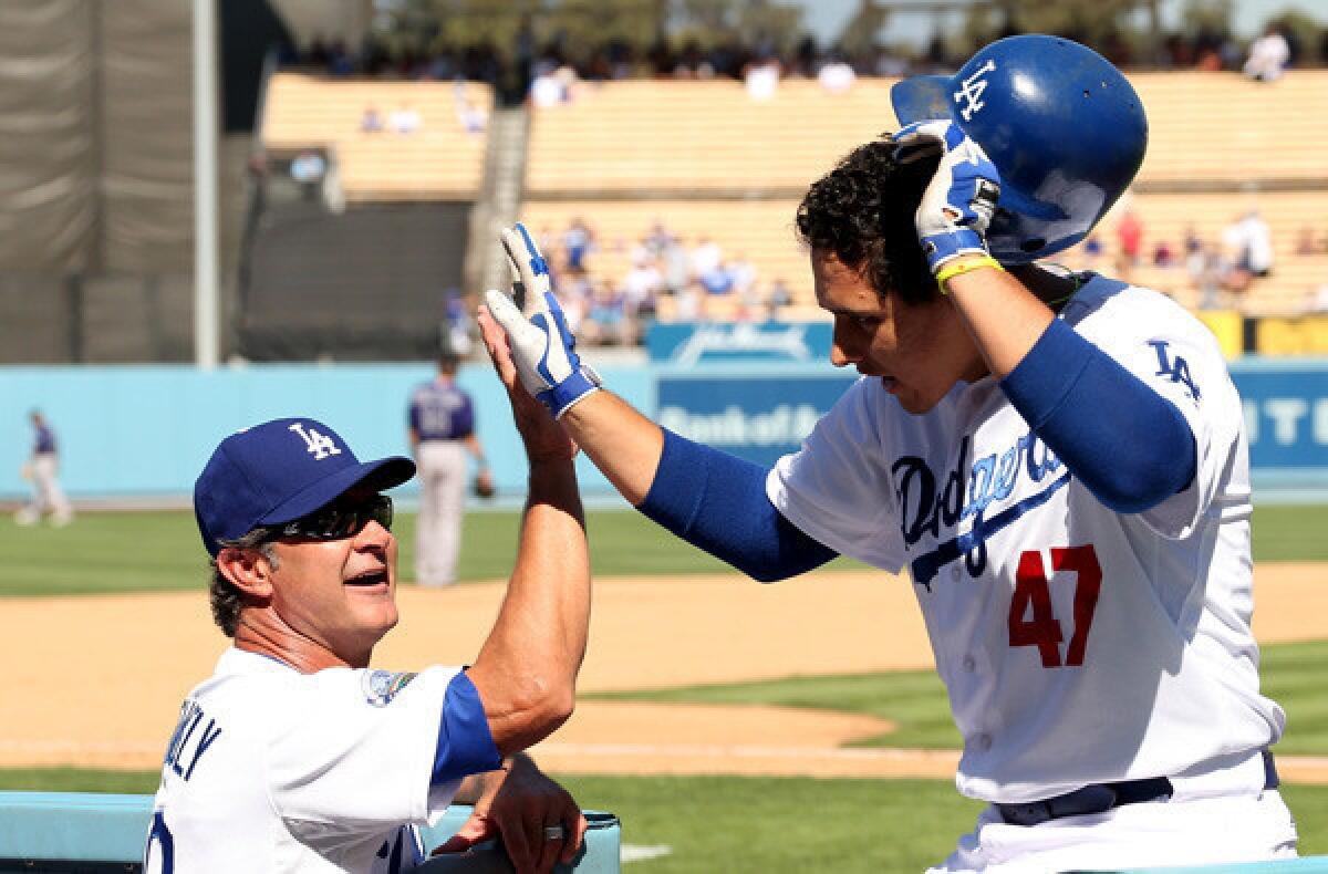 Dodgers Manager Don Mattingly high-fives infielder Luis Cruz after he hit a two-run home run against the Rockies.